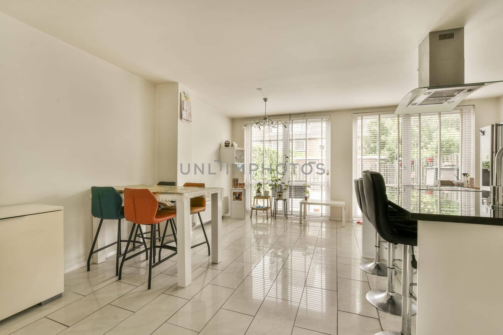 a kitchen and dining area in a house with white tiles on the floor, walls, floors and ceilings