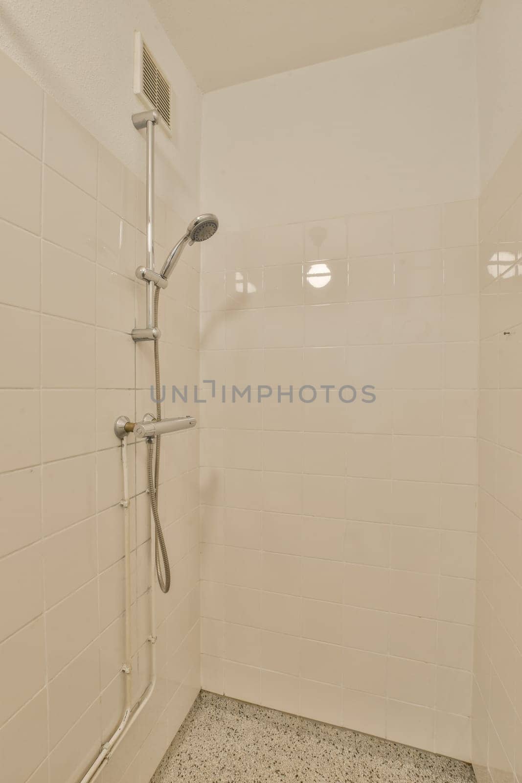 a white shower in a white tiled bathroom by casamedia