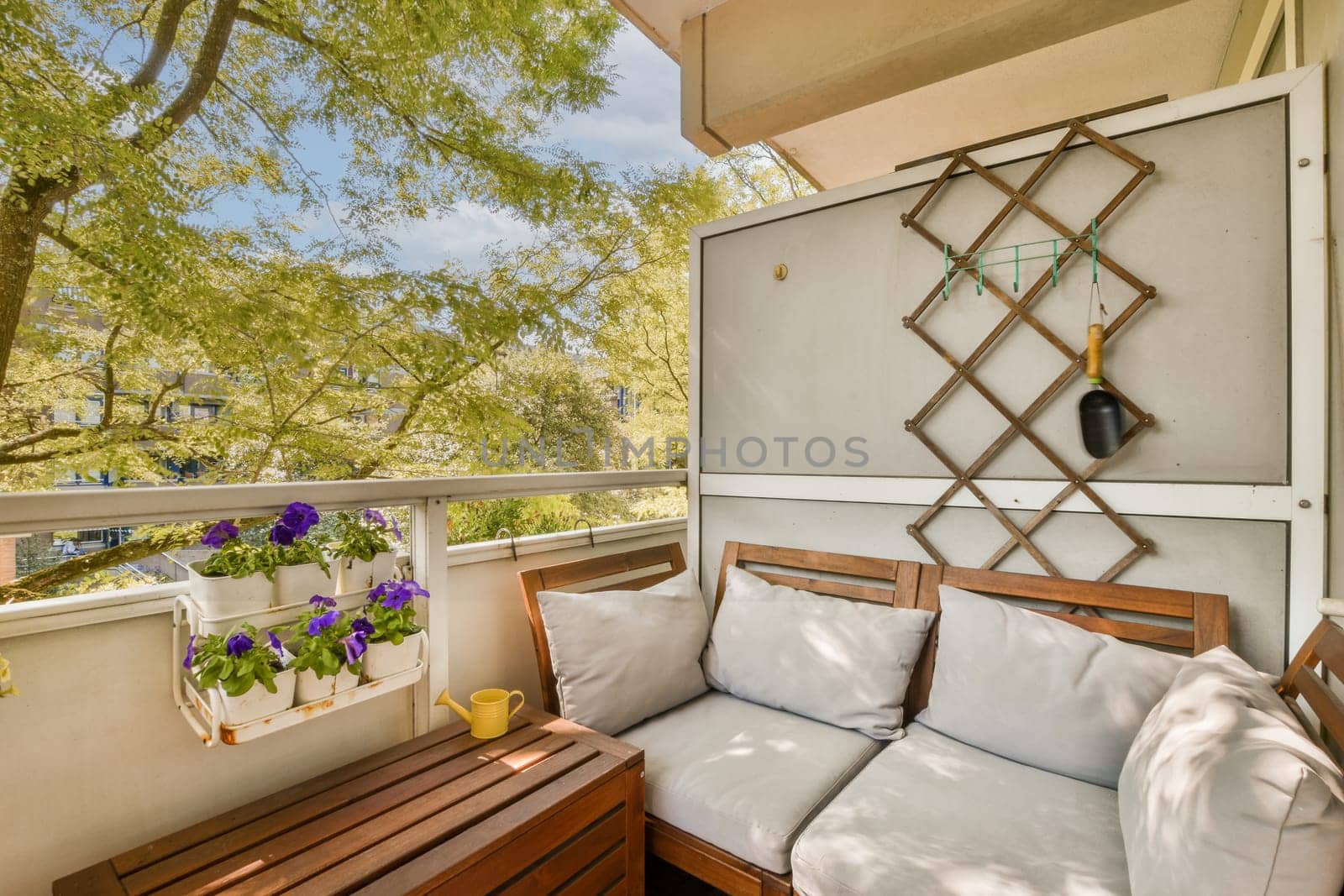 an outdoor living area with wooden furniture and plants on the balcony overlooking trees in the distance are bright blue skys