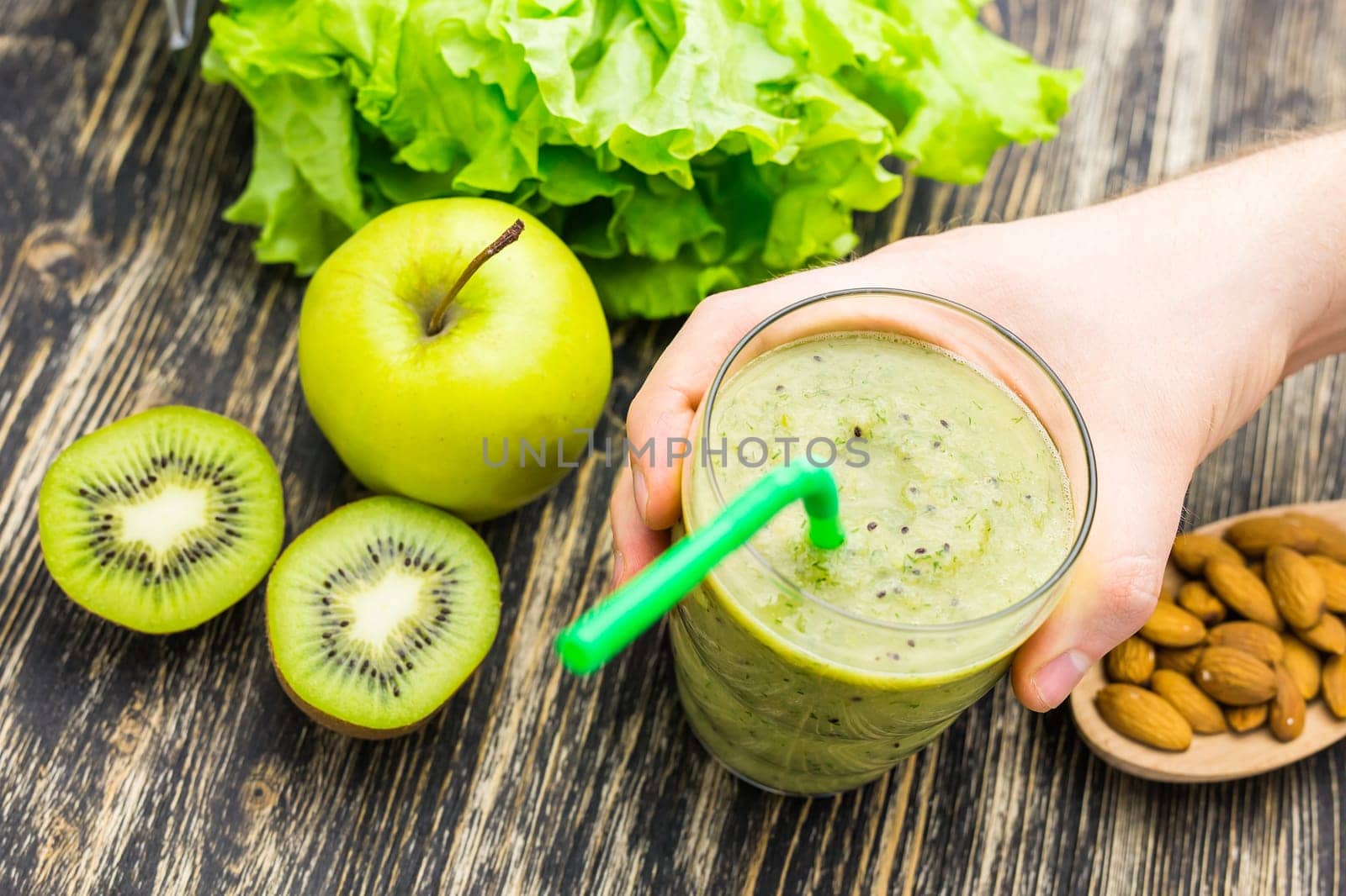 Healthy green smoothie with kiwi, apple on rustic wood background