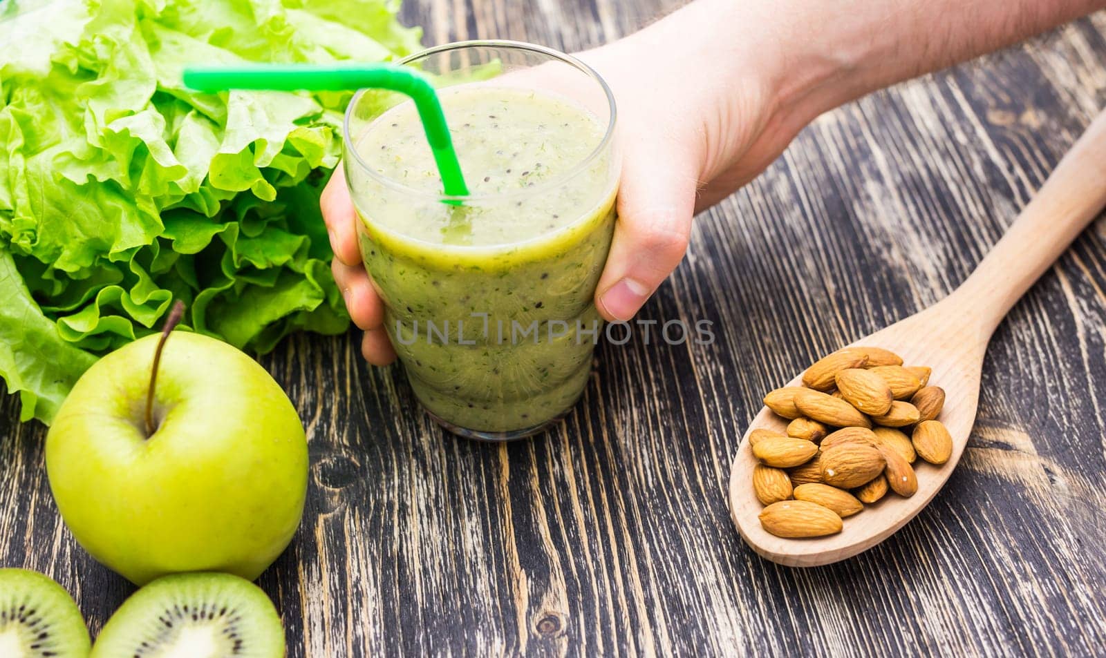 Healthy green smoothie with kiwi, apple on rustic wood background