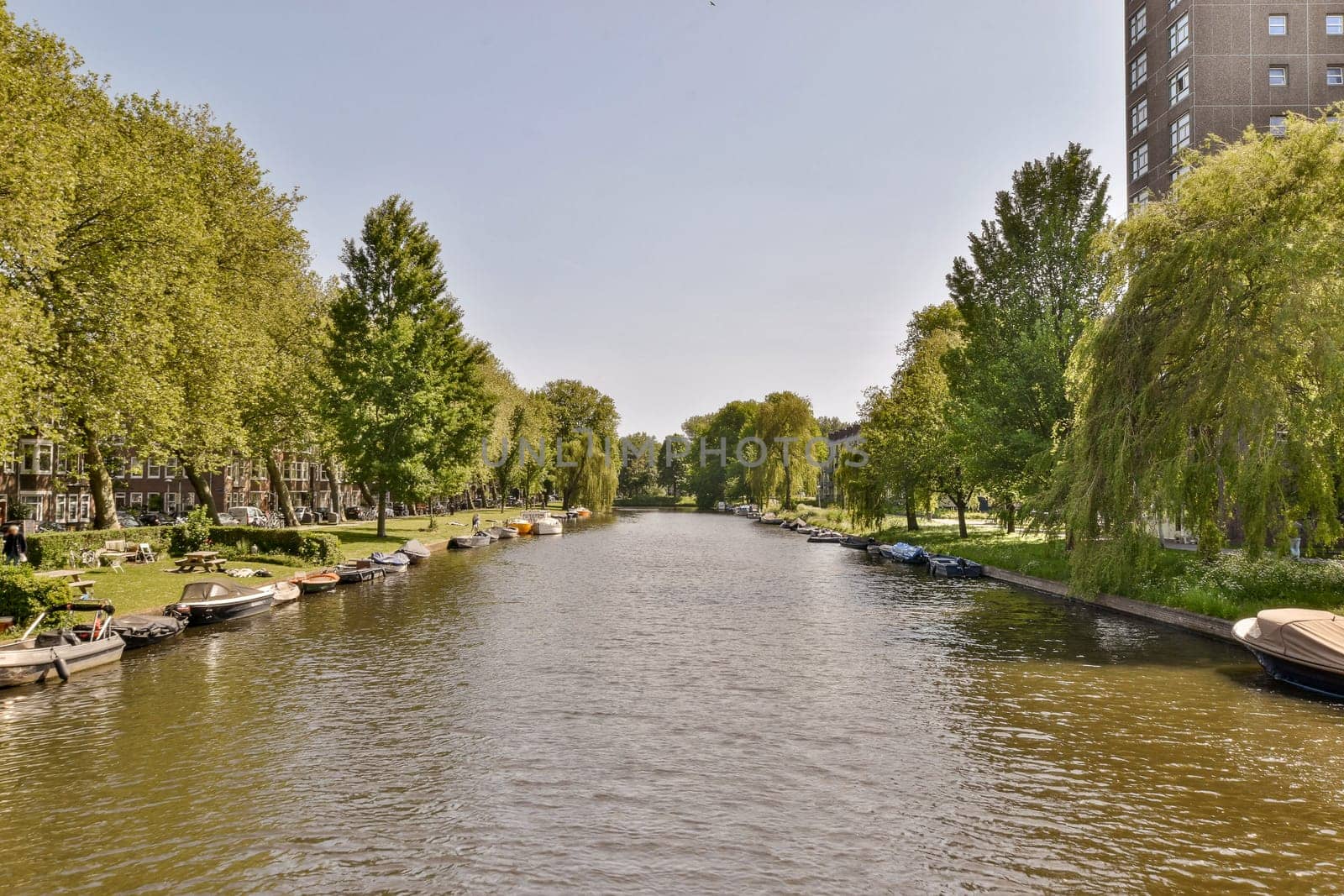 a river with boats on it and some buildings in the backgrunde area, as seen from across the water