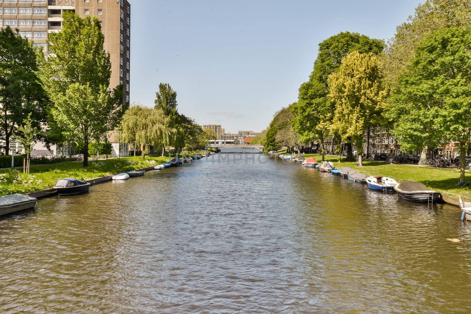 a canal with boats lined up on the side of by casamedia