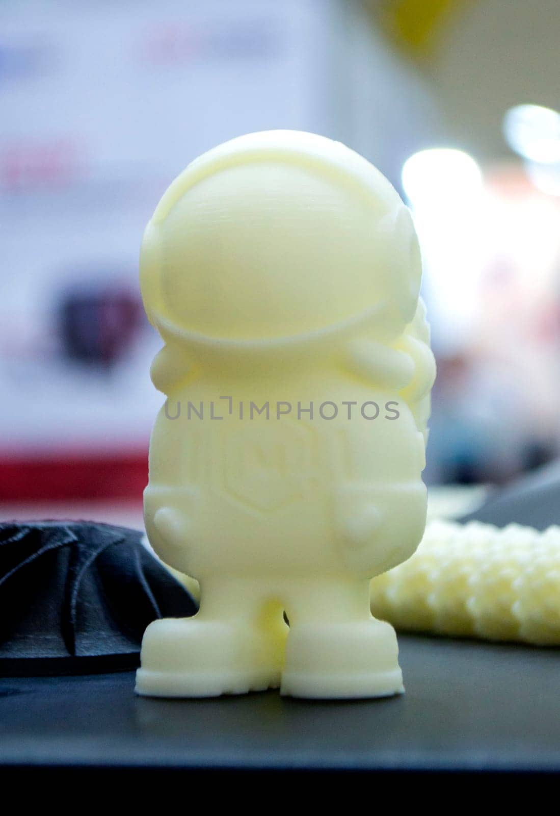 3D printer printing prototype of toy from molten plastic. Process of creating prototype model of toy on 3D printer from yellow melted plastic close-up. Additive new printer technology. Modern printing