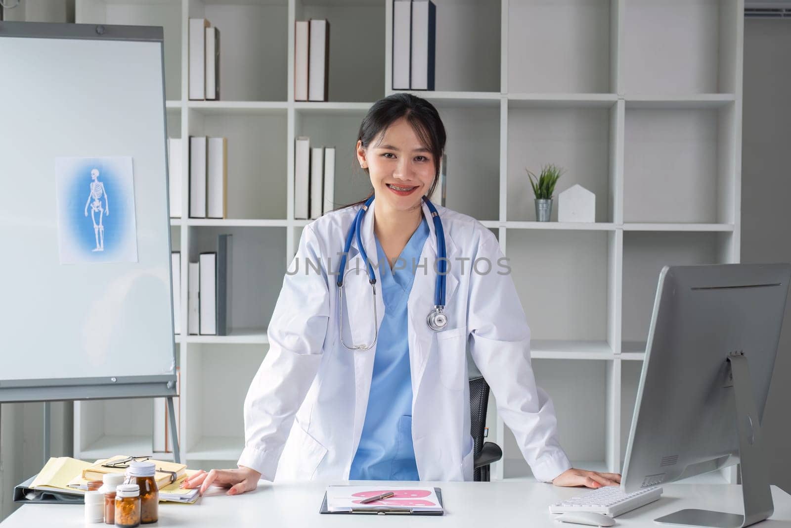 Portrait of a smiling female doctor wearing a medical coat and stethoscope in a hospital office. Medical and healthcare concept.