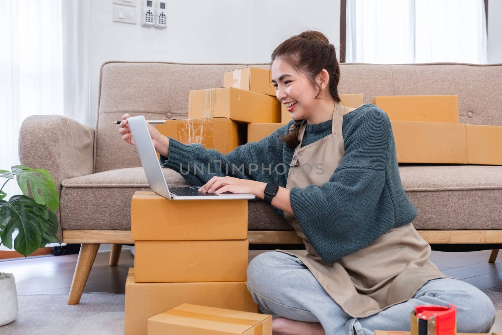 Startup small business entrepreneur SME, asian woman packing cloth in box. Portrait young Asian small business owner home office, online sell marketing delivery, SME e-commerce telemarketing concept.