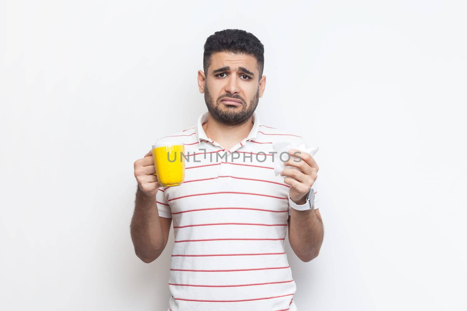 Sad unhappy unhealthy man with yellow cup, looking at camera, feels bad, frowning face by Khosro1