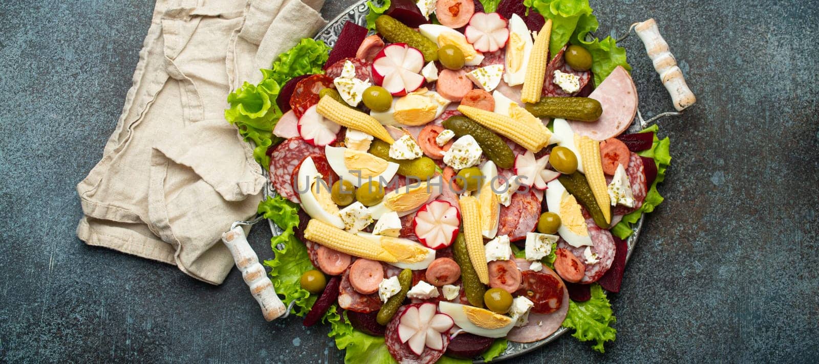 Fiambre, salad of Guatemala, Mexico and Latin America, served on large plate top view. Festive dish for All Saints Day (Day Of The Dead) celebration made of cold cuts, sausages, pickled vegetables by its_al_dente
