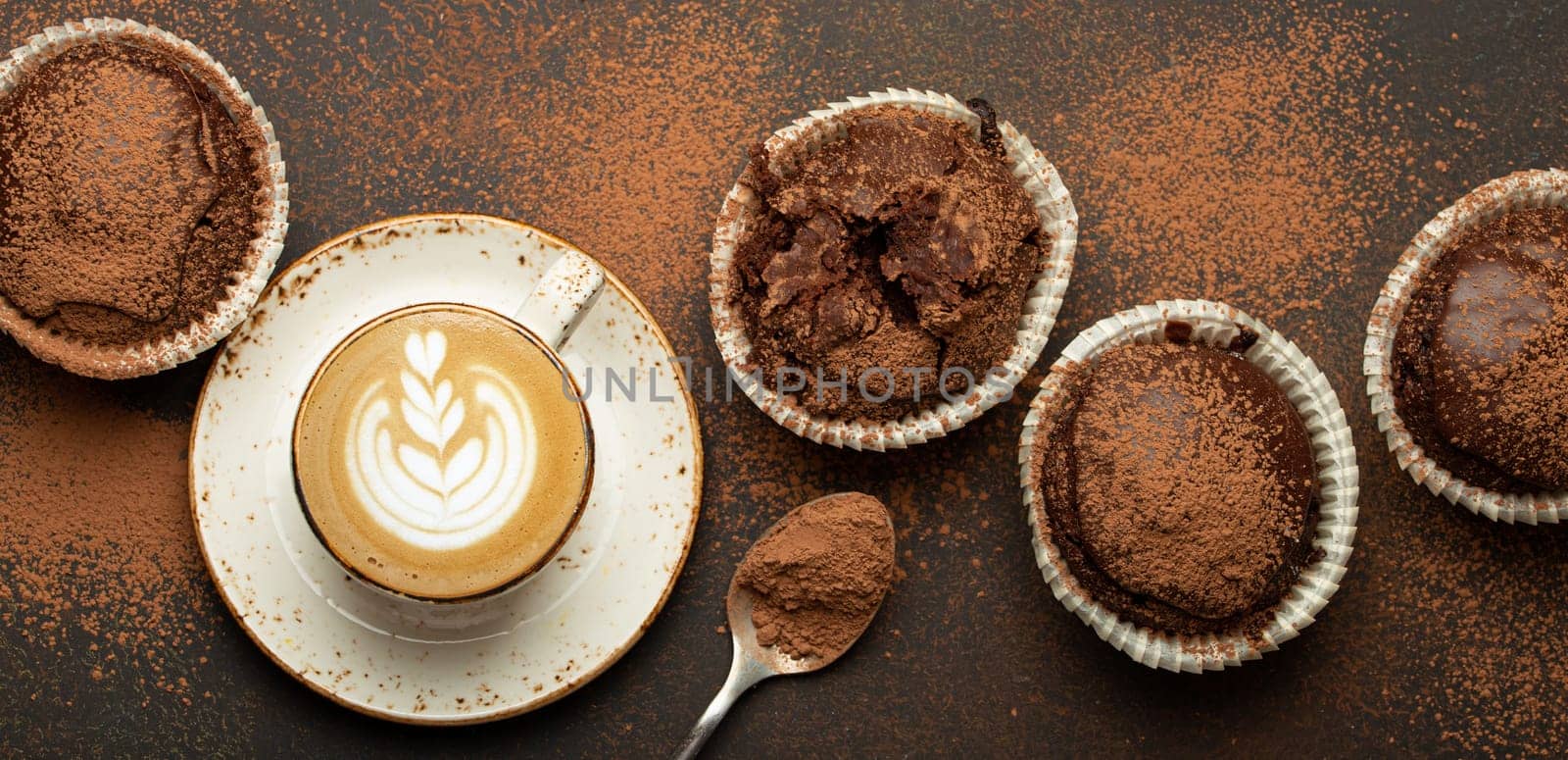 Chocolate and cocoa browny muffins with coffee cappuccino in cup top view on brown rustic stone background, sweet homemade dark chocolate cupcakes by its_al_dente