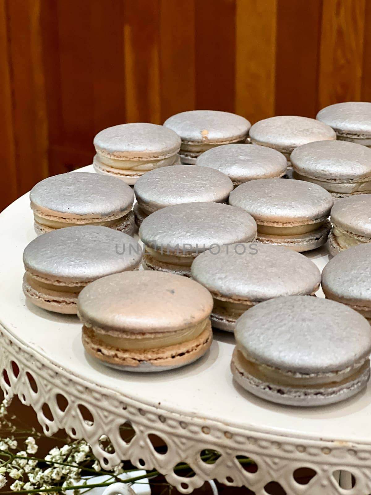 Silver French macarons in various flavors made to look extra fancy at a wedding reception dessert buffet.