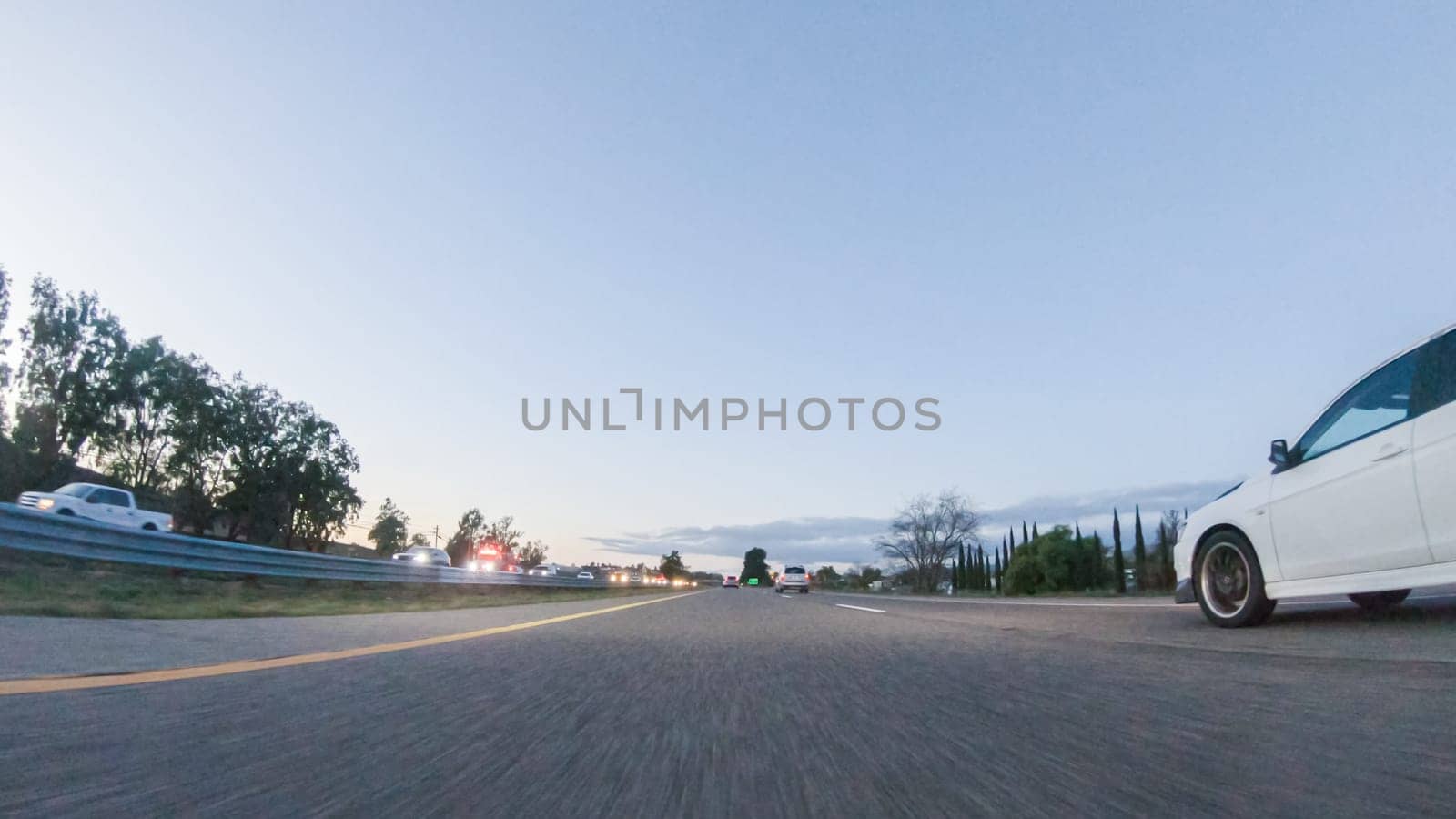 Los Angeles, California, USA-December 4, 2022-POV-As the sun sets, driving on HWY 101 near Pismo Beach, California becomes a captivating experience with the sky painted in shades of orange and pink, casting a warm glow over the coastal landscape.