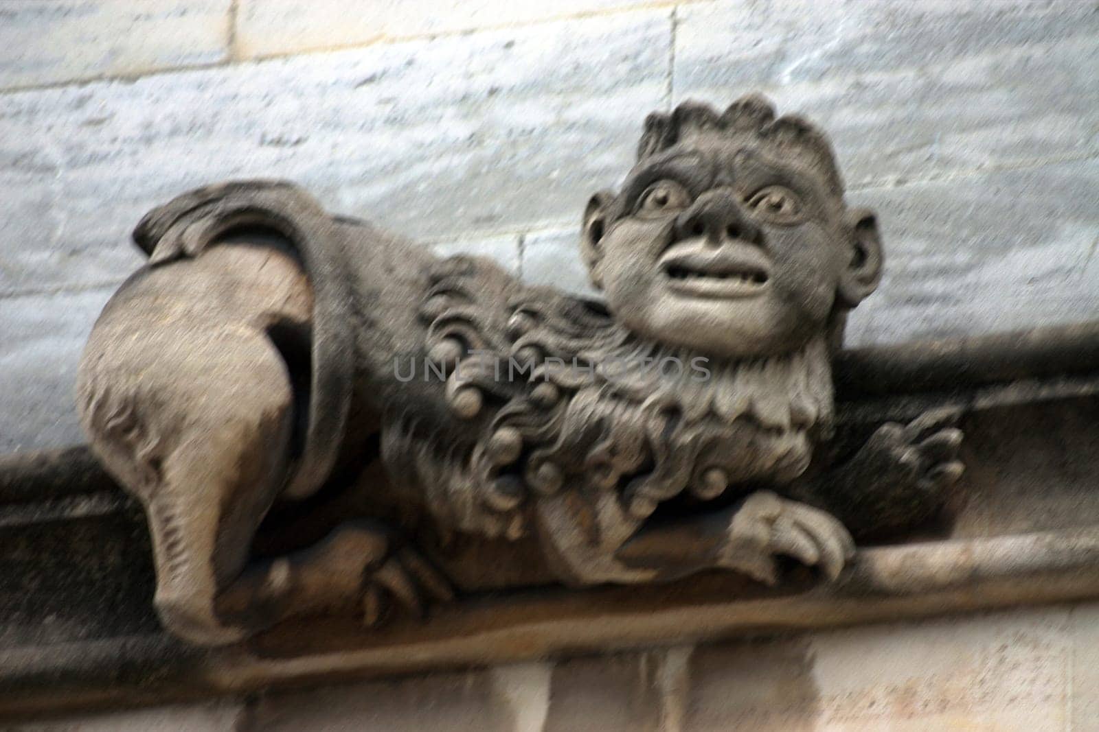 A curious gargoyle or grotesque sculptures on historic university buildings in Oxford, UK.