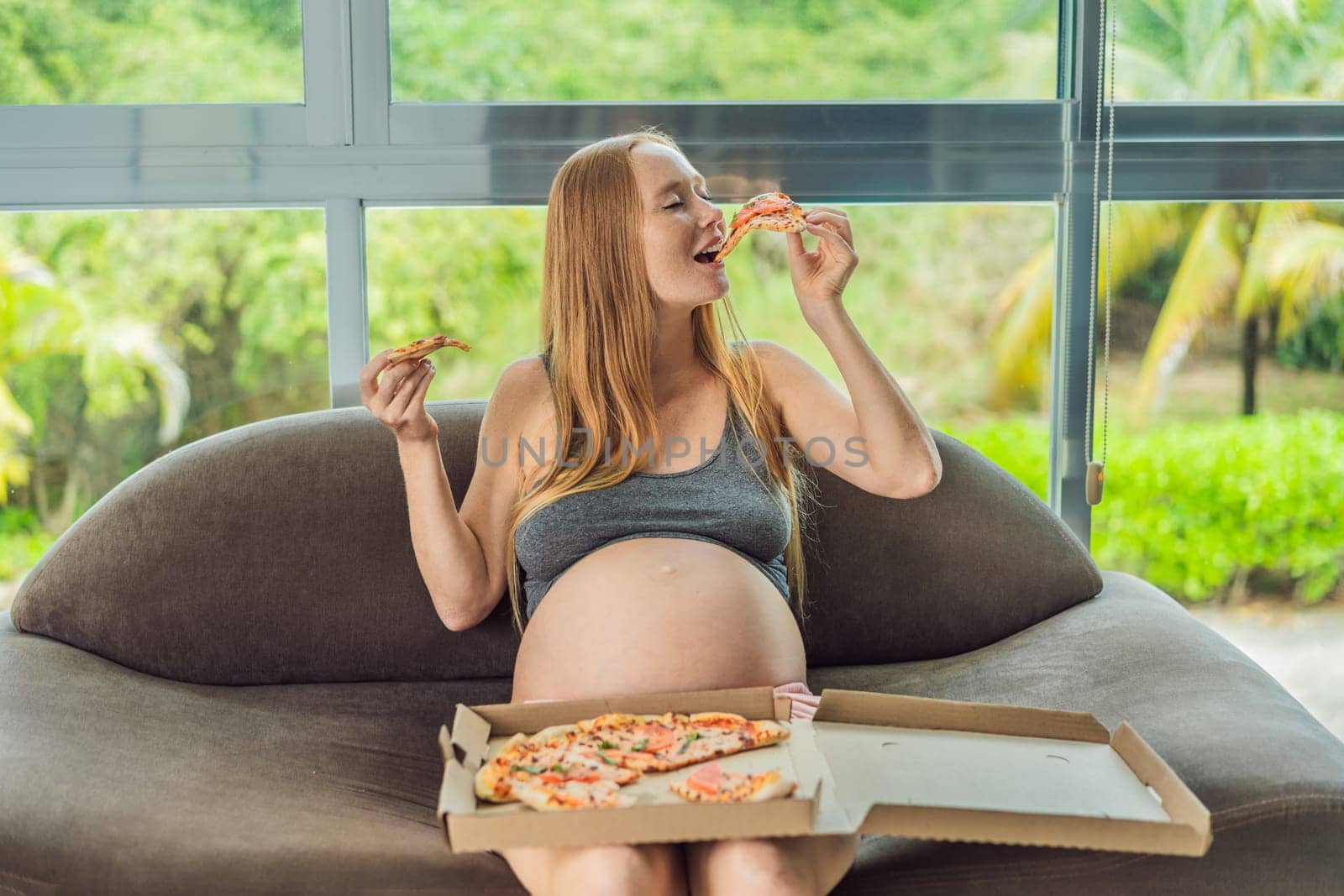 A pregnant woman enjoys a slice of pizza, savoring a moment of indulgence while satisfying her craving for a delightful, comforting treat. Excited Pregnant Young Lady Enjoying Pizza Holding Biting Tasty Slice Posing With Carton Box. Junk Food Lover Eating Italian Pizza. Unhealthy Nutrition Cheat Meal.