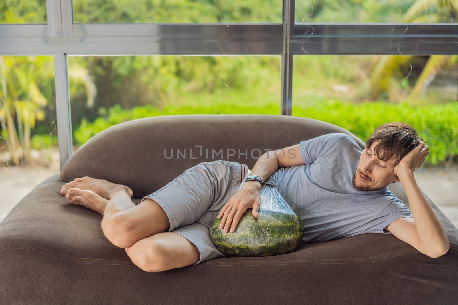 A humorous image: a pregnant woman and her husband playfully use a watermelon in place of a belly, comically highlighting the challenges of navigating with a pregnant bump by galitskaya