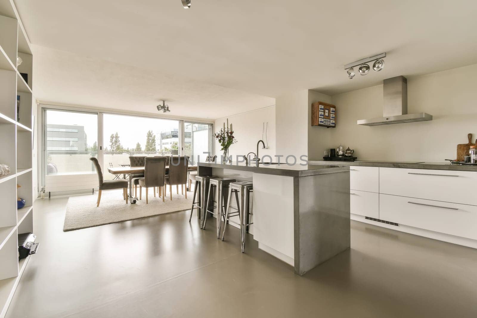 a large kitchen with an island and a dining table by casamedia