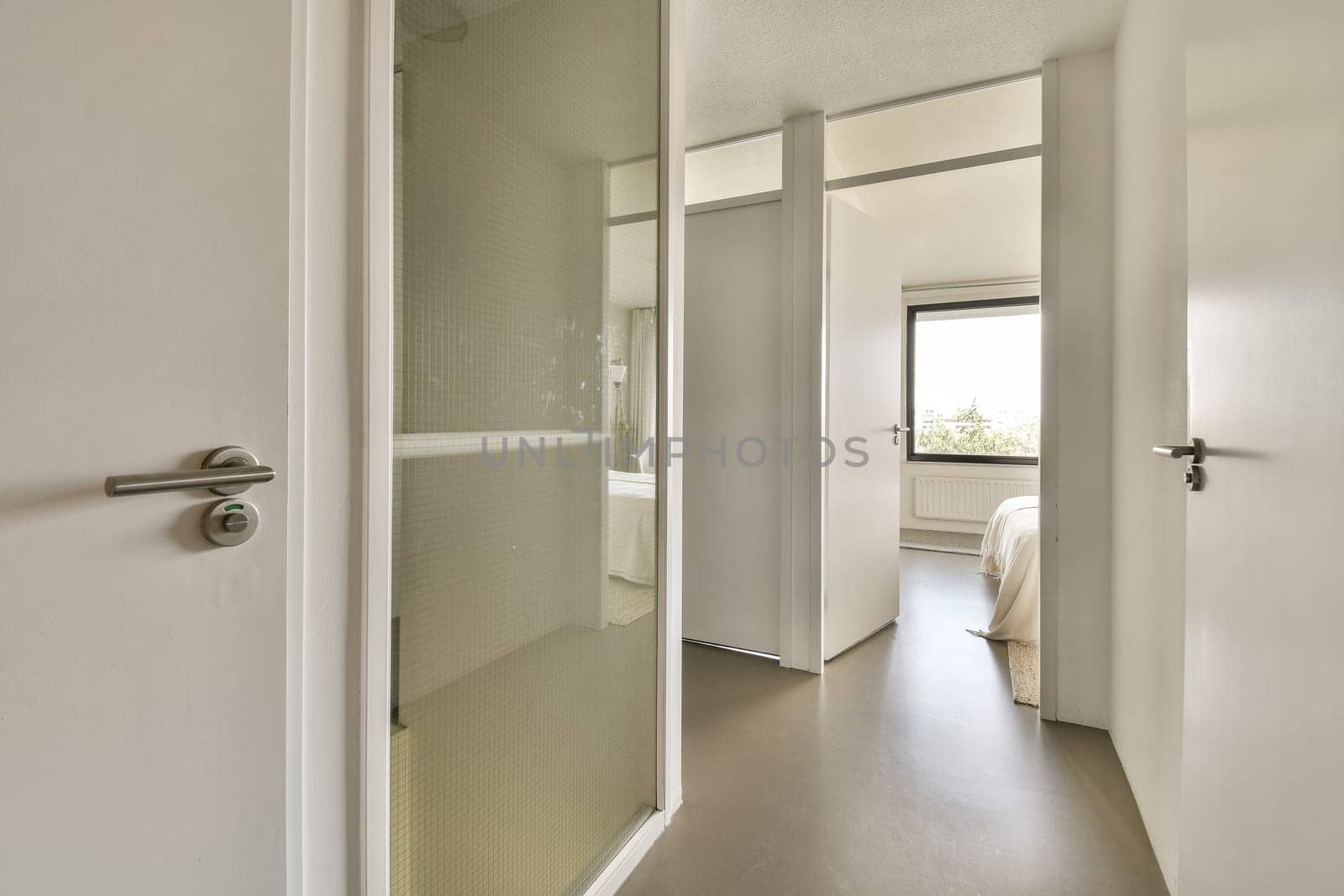 a bathroom with a shower and toilet in the corner, as seen through an open door on the right side