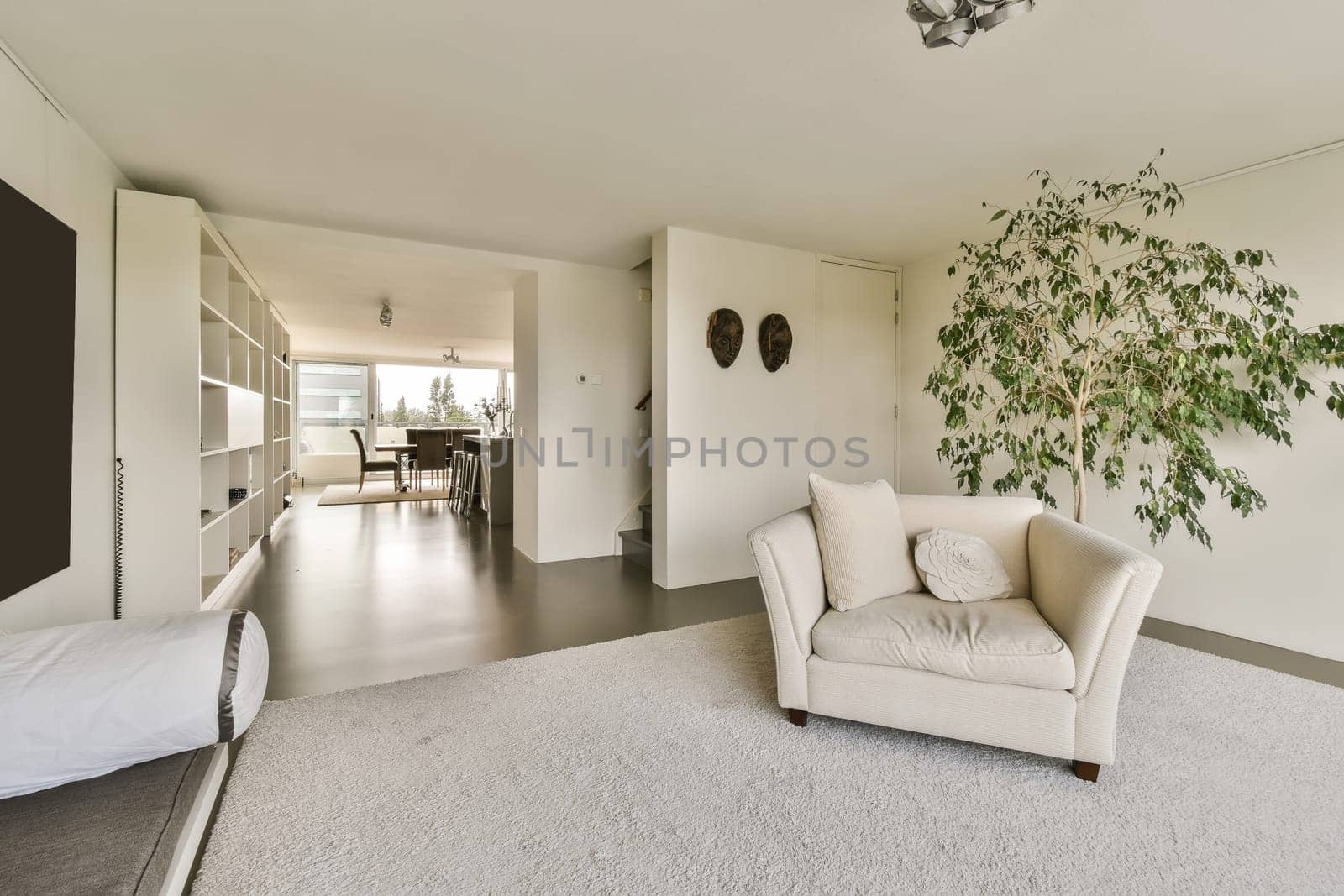 a living room with a white couch and a tree by casamedia