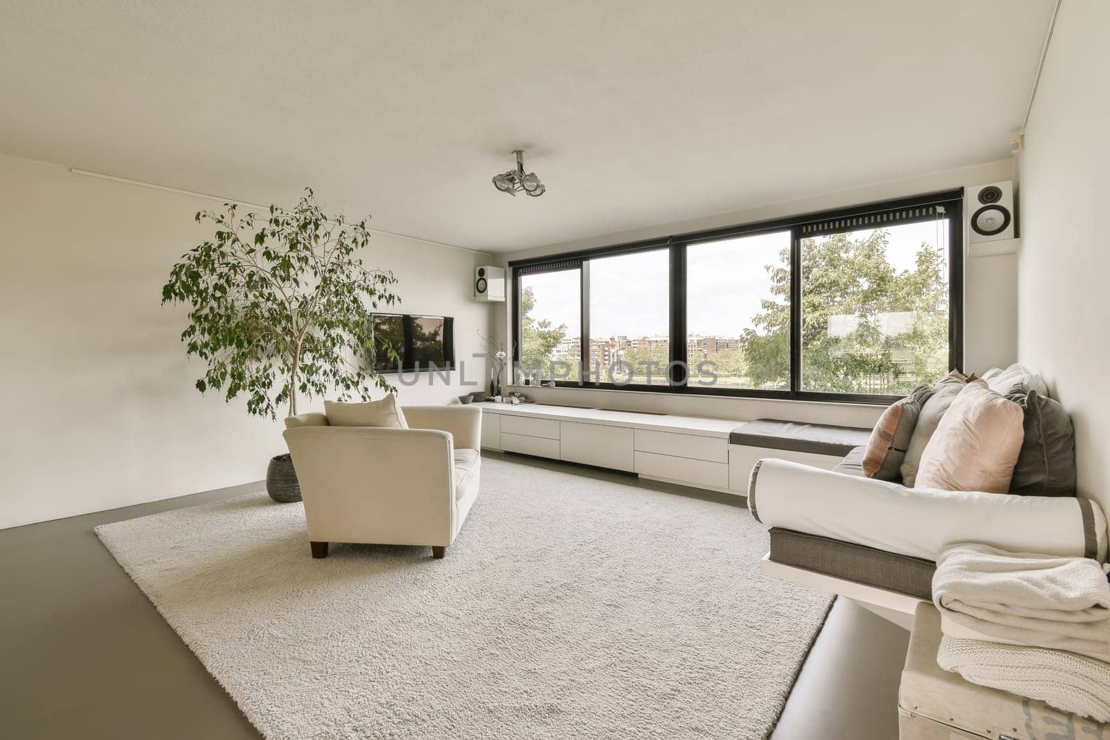 a living room with white furniture and a large window by casamedia