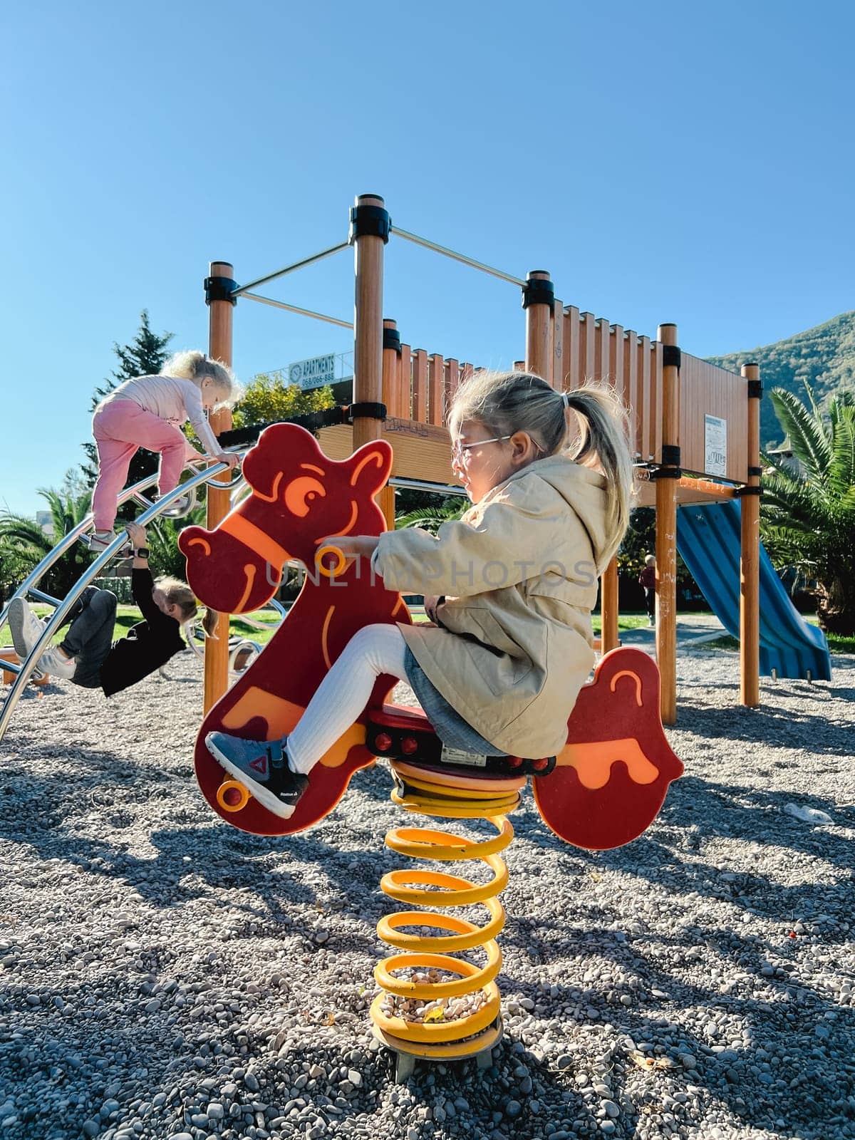 Little girl swings on a swing-spring on the playground. High quality photo