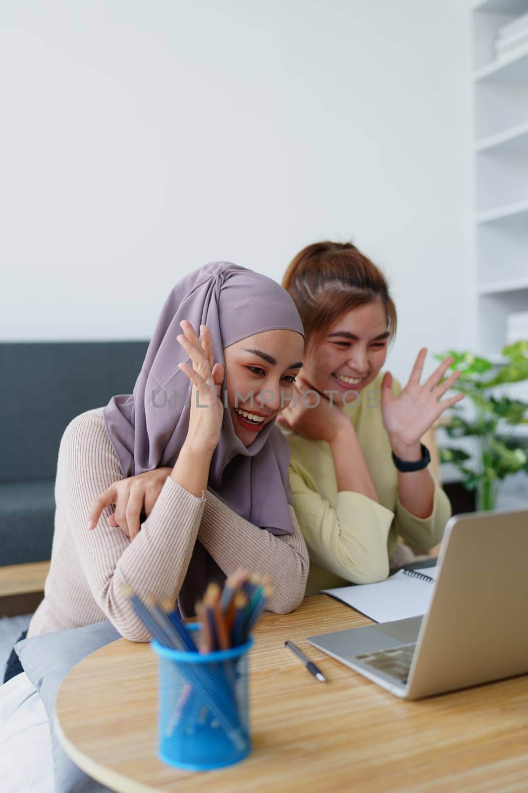 Muslim undergraduates and Asian women are studying online using computers. by Manastrong