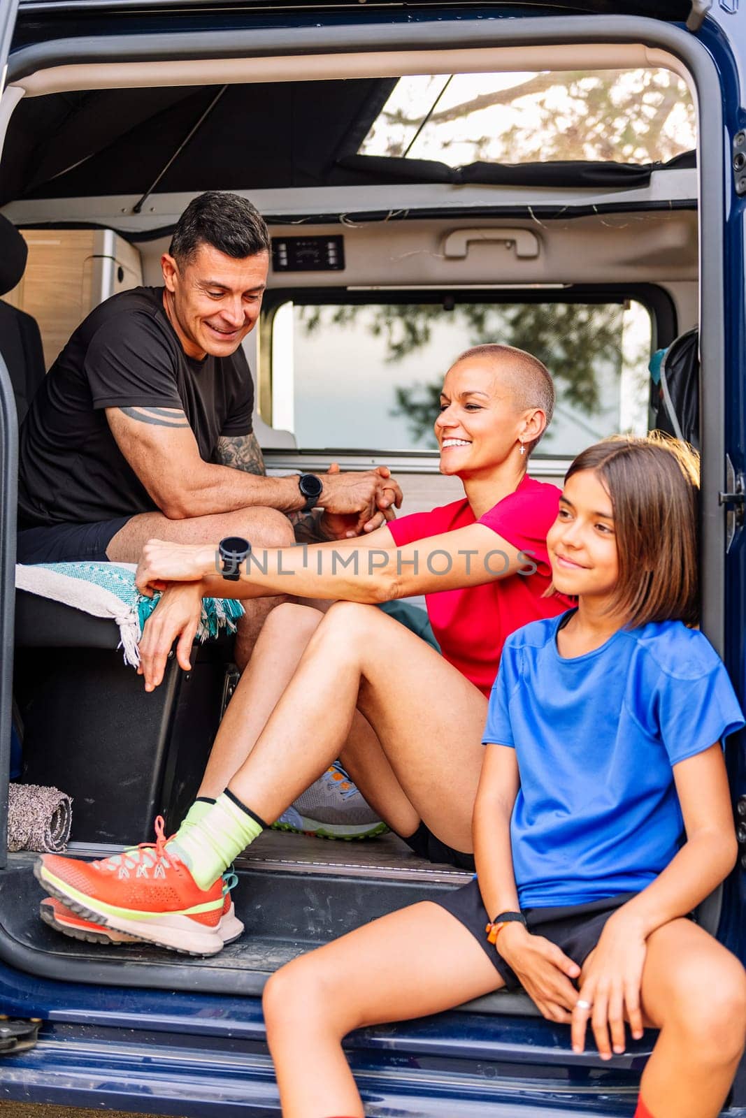 family resting in van after doing sports in nature by raulmelldo