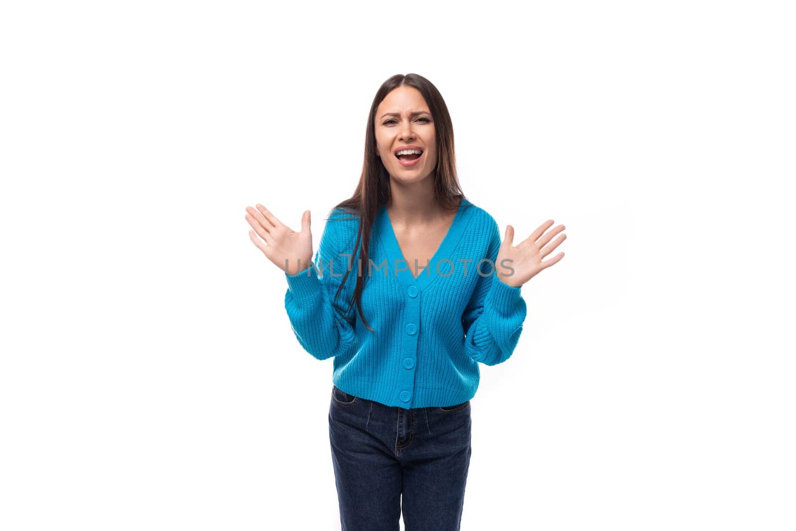 surprised young brunette lady dressed in blue casual button up cardigan on white background.