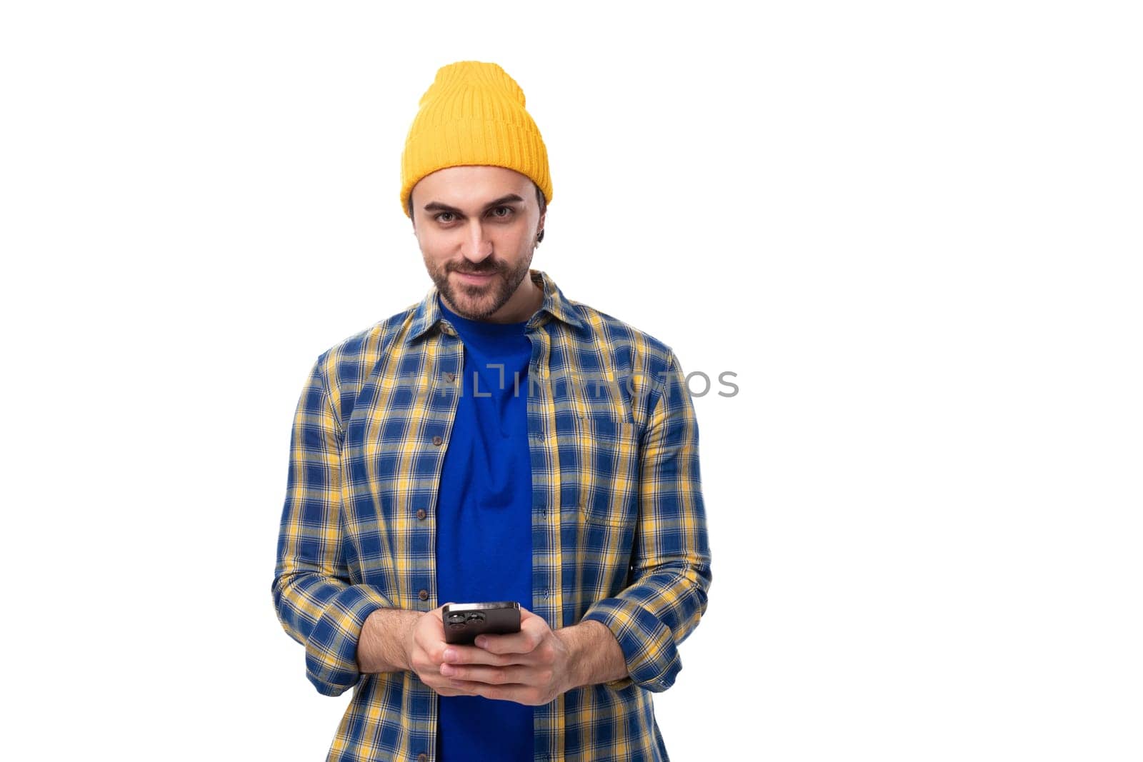 young brutal brunette man with a beard and mustache chatting on a mobile phone in social networks.