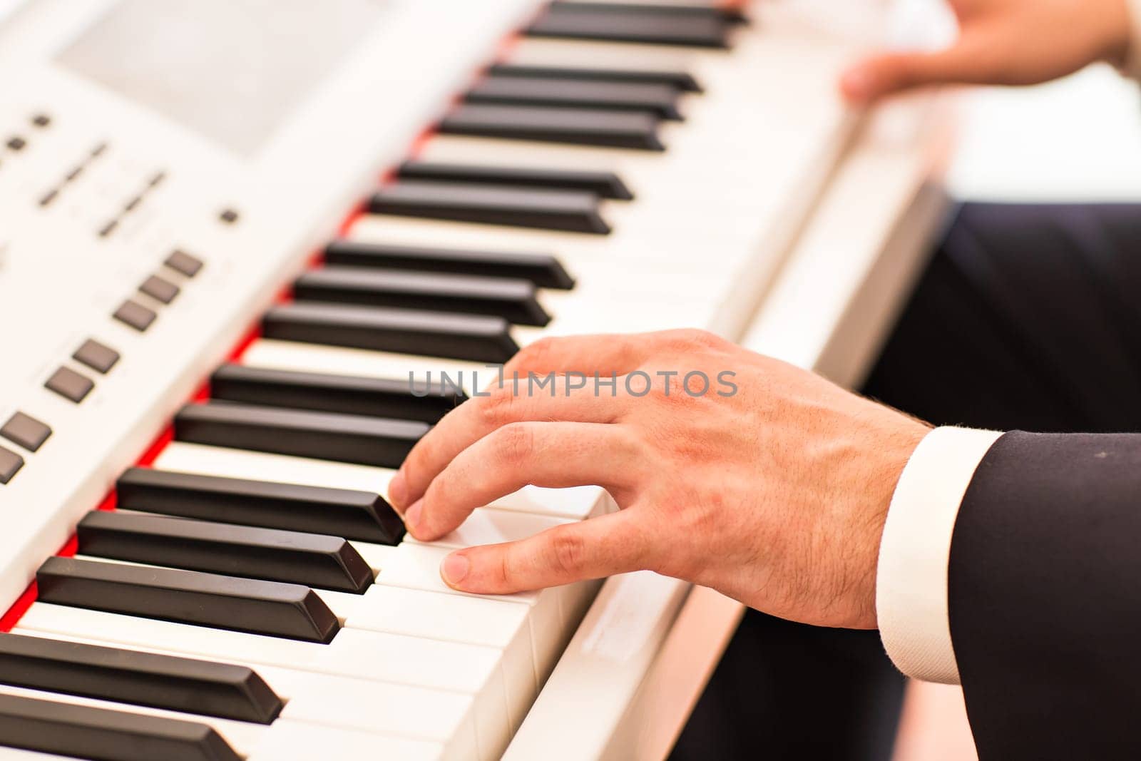 Hands of musician close-up. Pianist playing on electric piano by Satura86