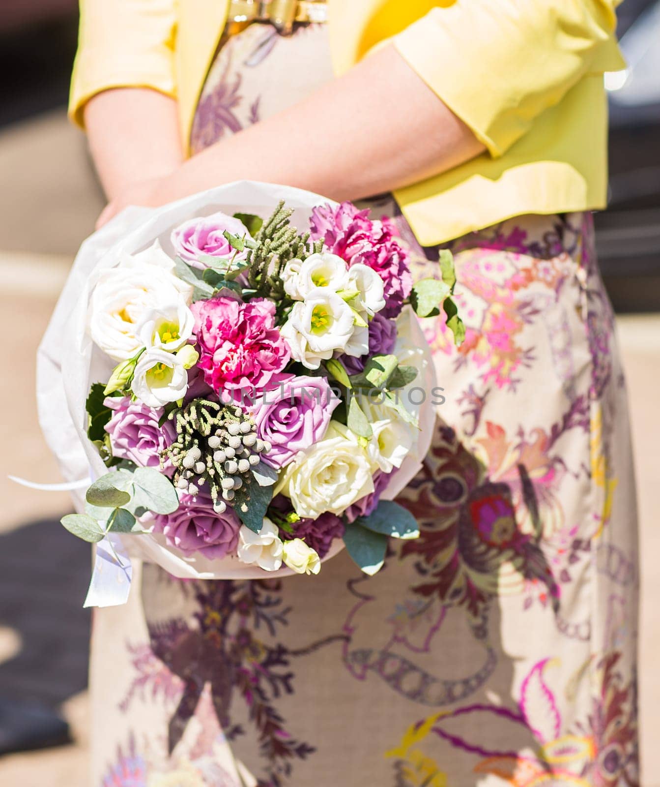 A womans hand is holding a bouquet of flowers