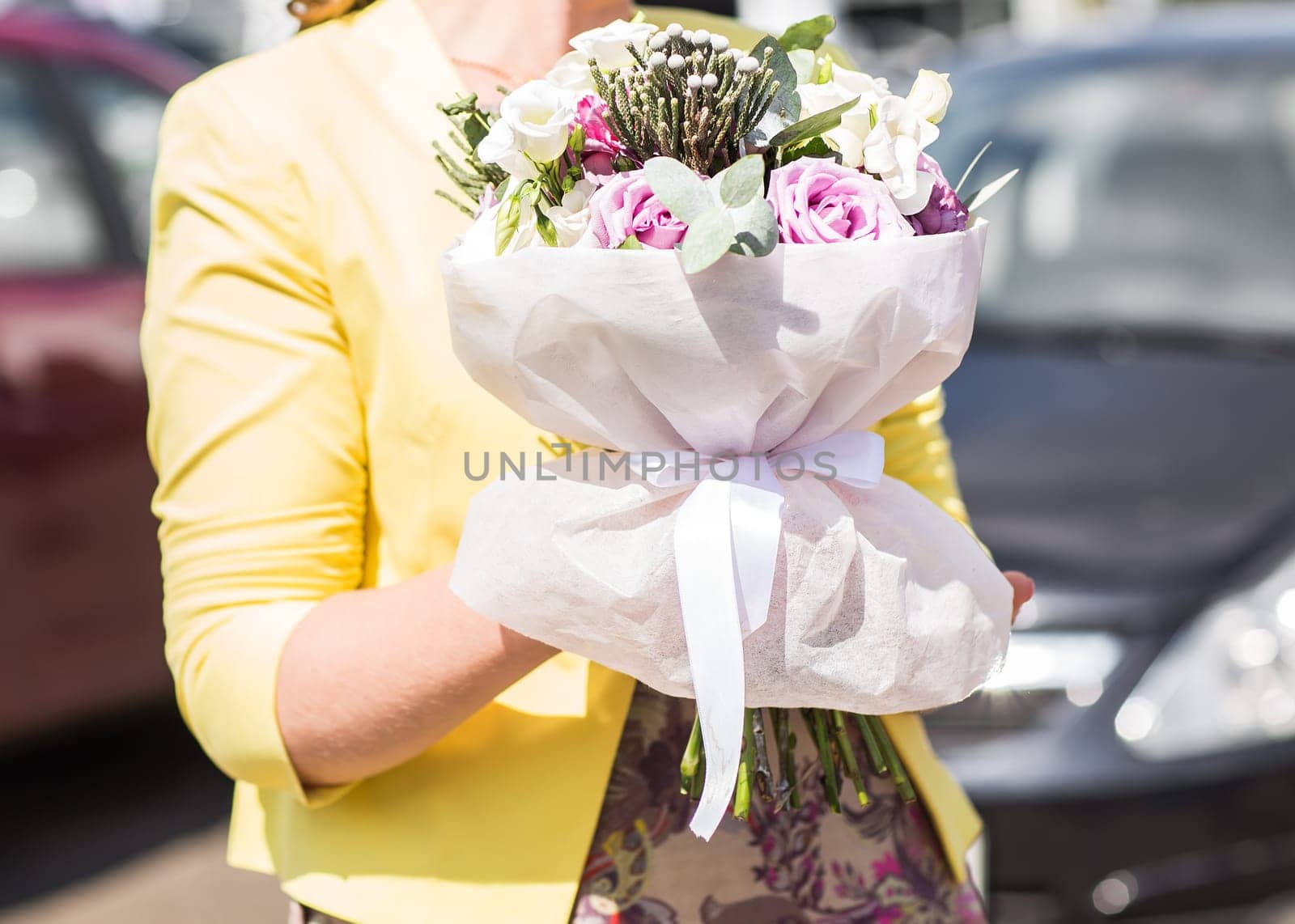 A womans hand is holding a bouquet of flowers