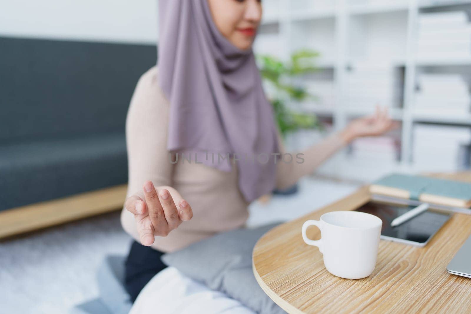 Muslim female employee Meditate while working in the office. by Manastrong