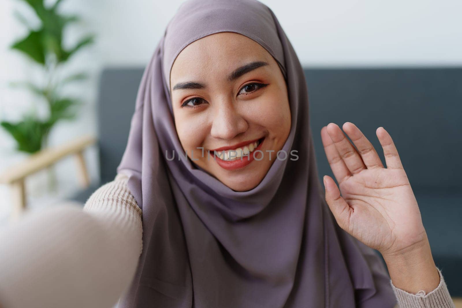 Muslim undergraduate student using mobile phone to contact friends