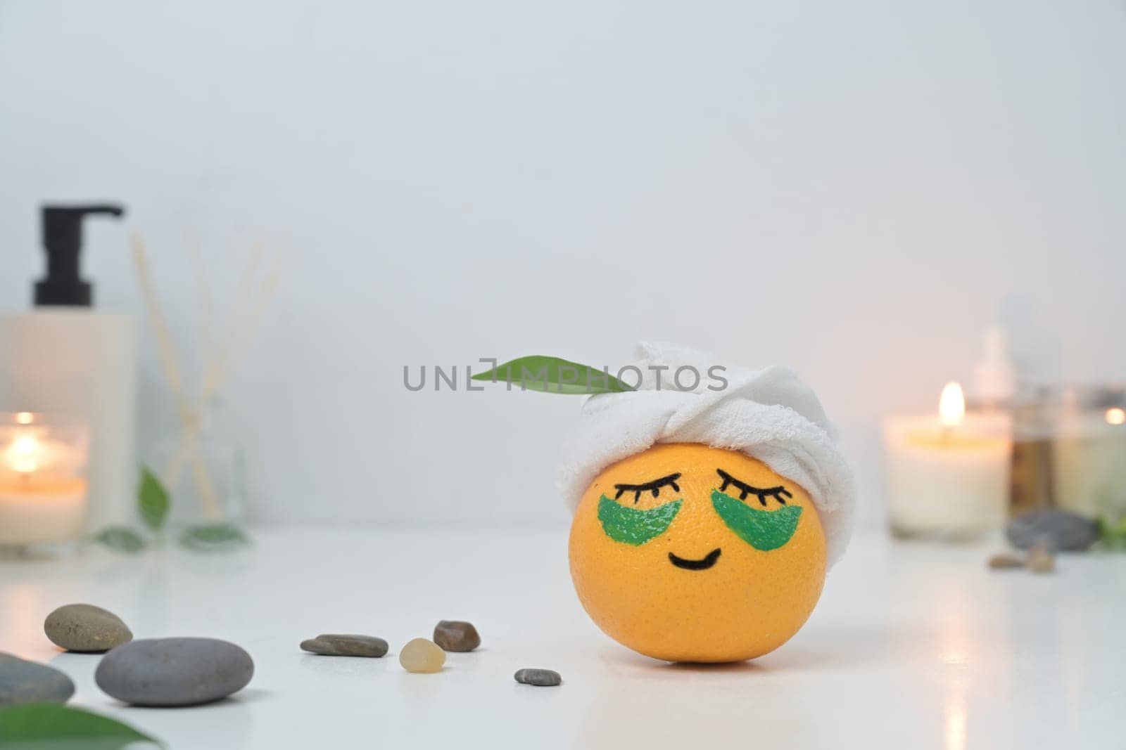 An orange in face mask and patches under eyes. Spa treatment and self care concept by prathanchorruangsak