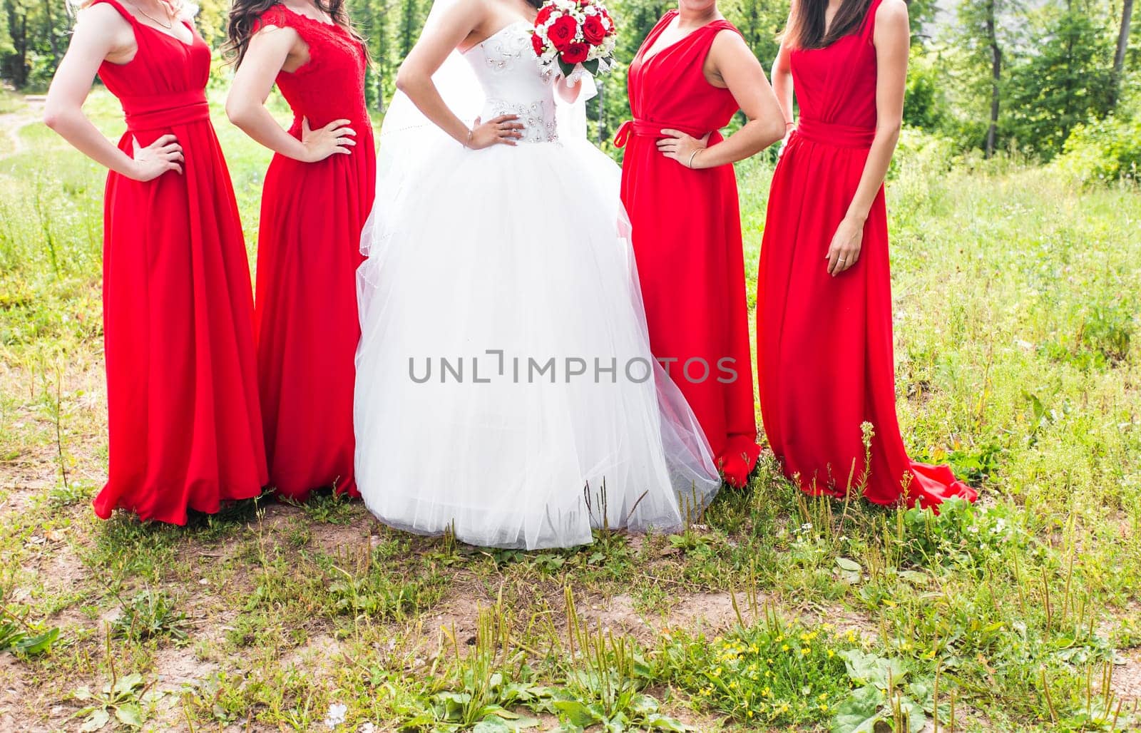 Bride with bridesmaids on the park on the wedding day