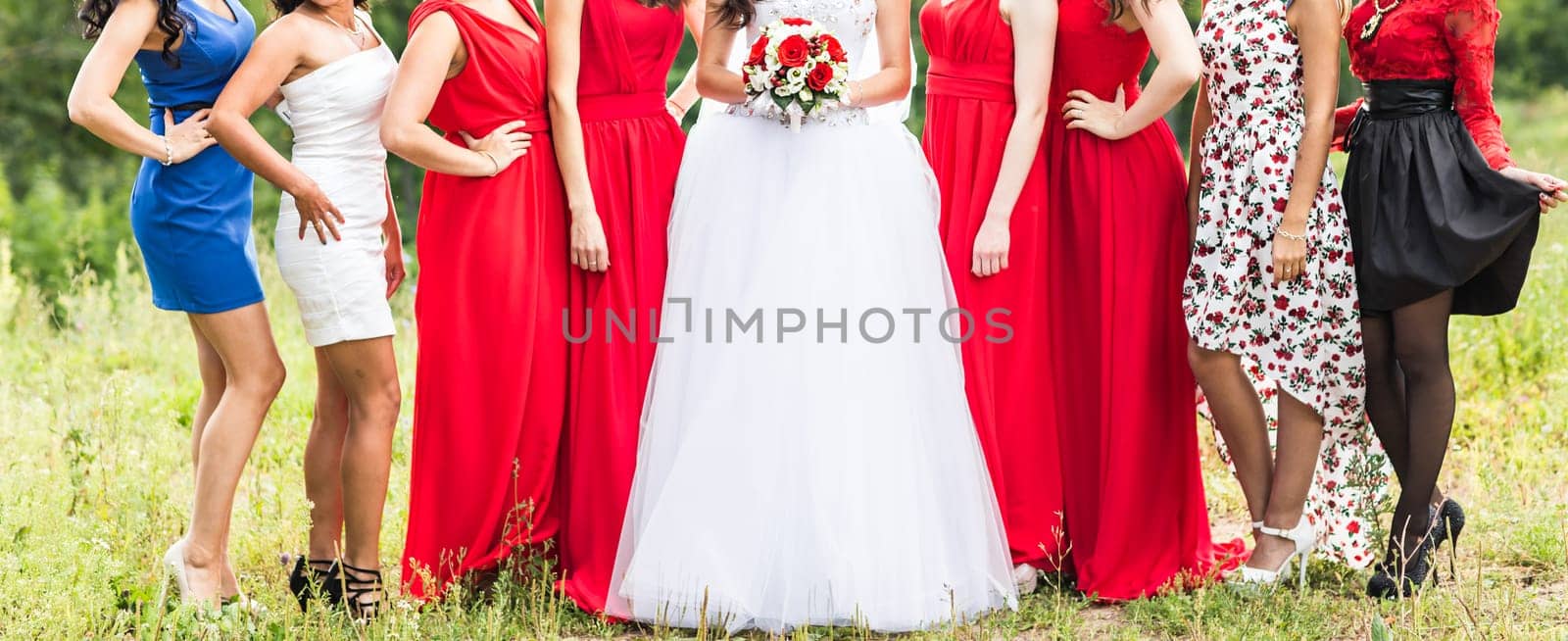 Bride with bridesmaids on the park on the wedding day