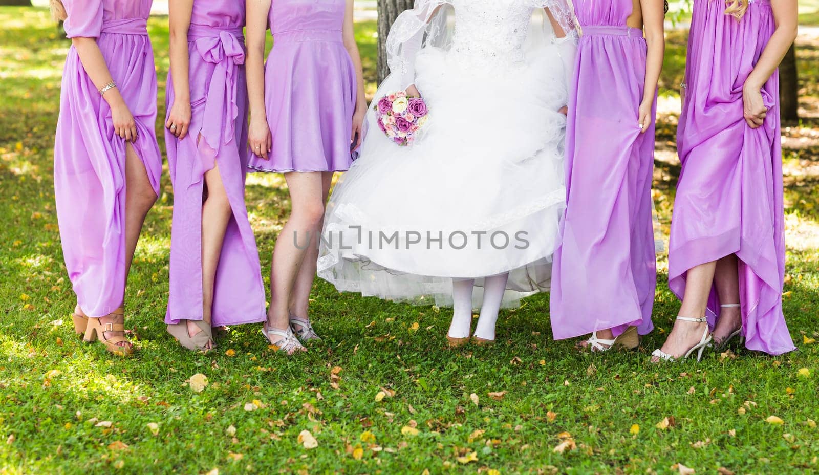 Bride and bridesmaids show off their shoes at wedding. by Satura86