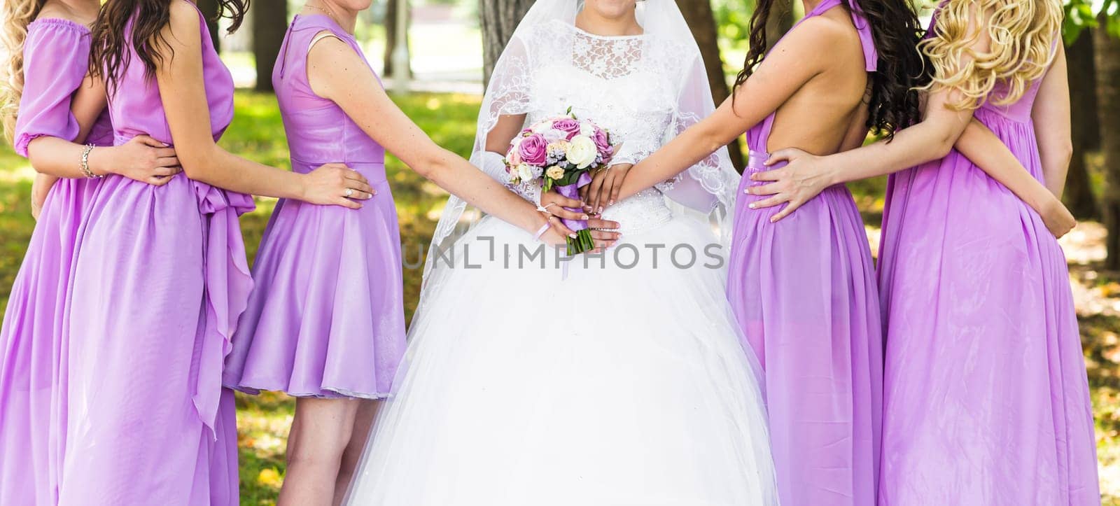 Bride with bridesmaids on the park on the wedding day