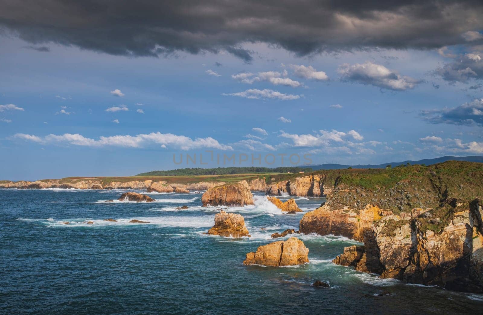 View of cliffs on the Asturian coast on a sunny day with blue sky and some clouds in the sky. by csbphoto