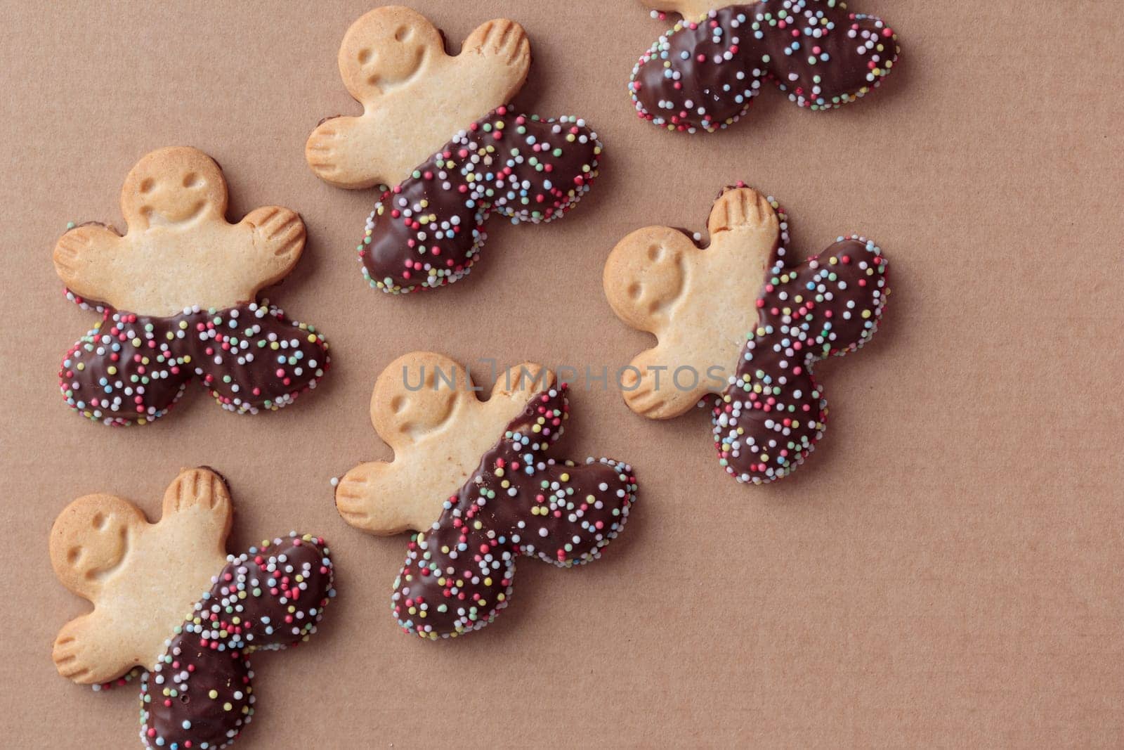 Freshly baked homemade christmas Gingerbread Man cookies with chocolate on the craft background with copy space