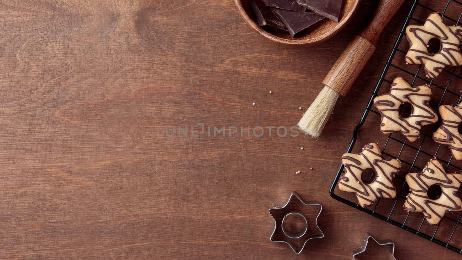 Freshly baked homemade star-shaped cookie with chocolate on the grid on the wooden table with a copy space, horizontal banner