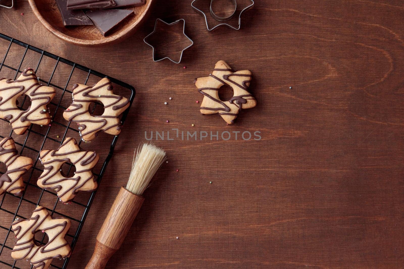 Freshly baked homemade star-shaped cookie with chocolate on the grid on the wooden table with a copy space, horizontal banner