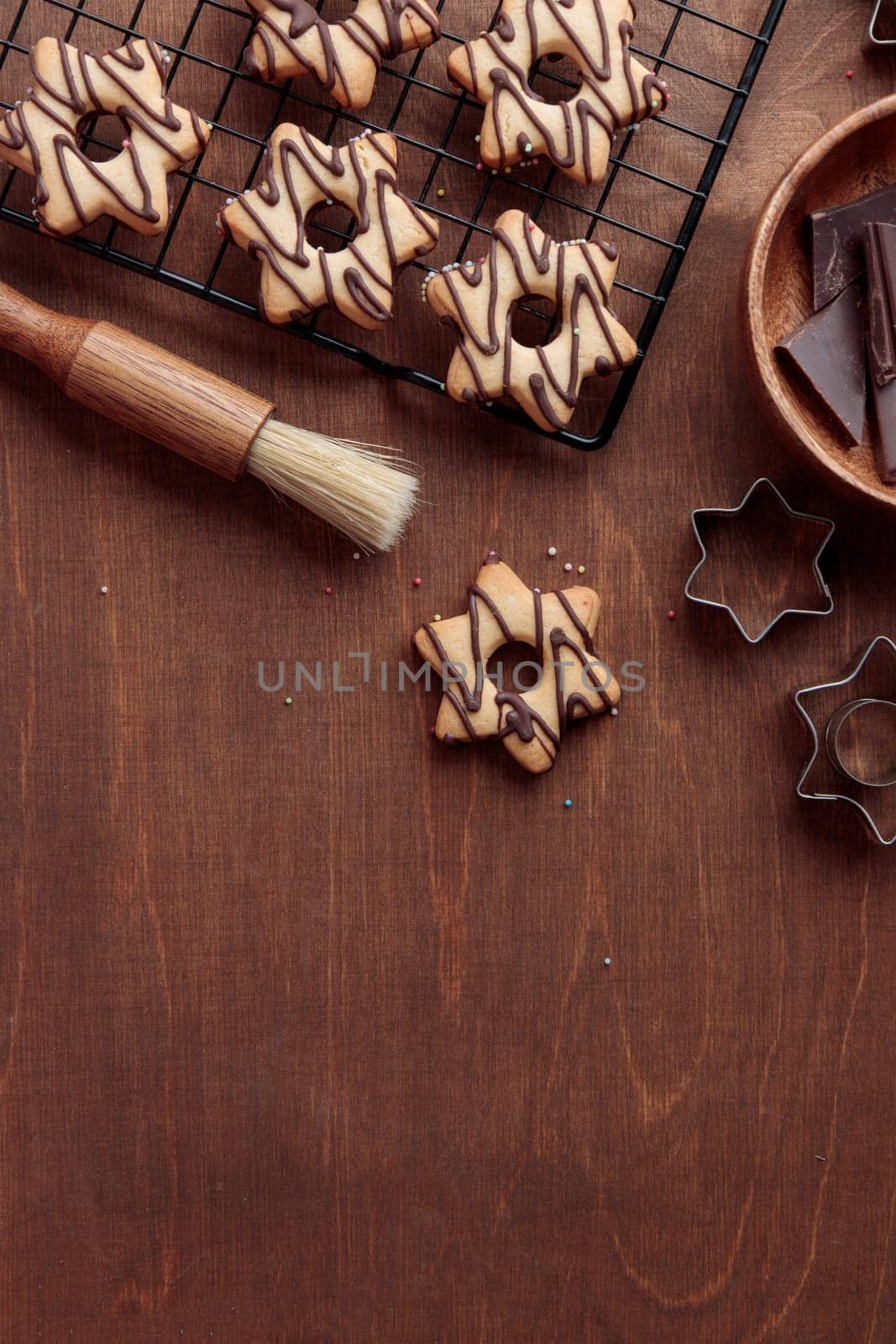 Freshly baked homemade star-shaped cookie with chocolate on the grid on the wooden table with a copy space, vertical