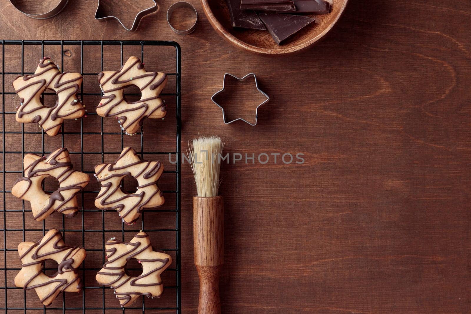 Freshly baked homemade star-shaped cookie with chocolate on the grid on the wooden table with a copy space, horizontal banner
