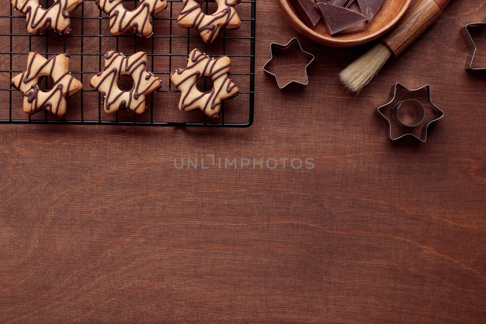 Freshly baked homemade star-shaped cookie with chocolate on the grid on the wooden table with a copy space, horizontal banner