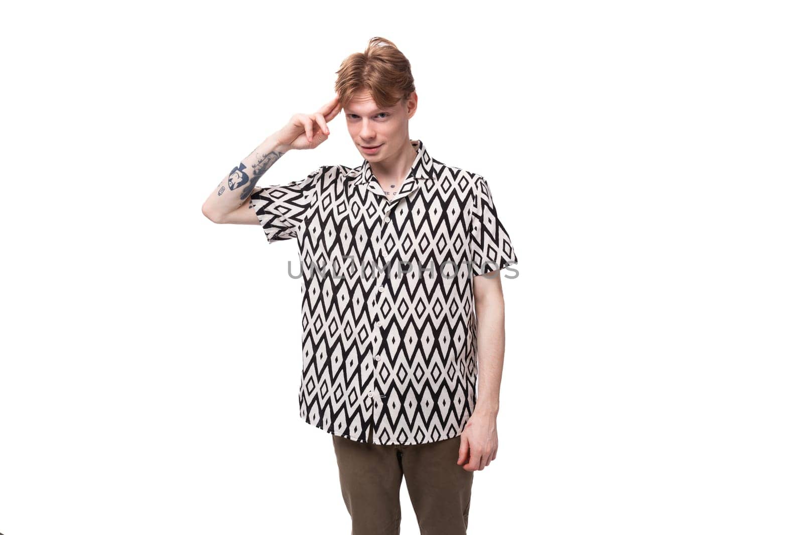 young red-haired man in a rhombus print summer shirt is brainstorming.