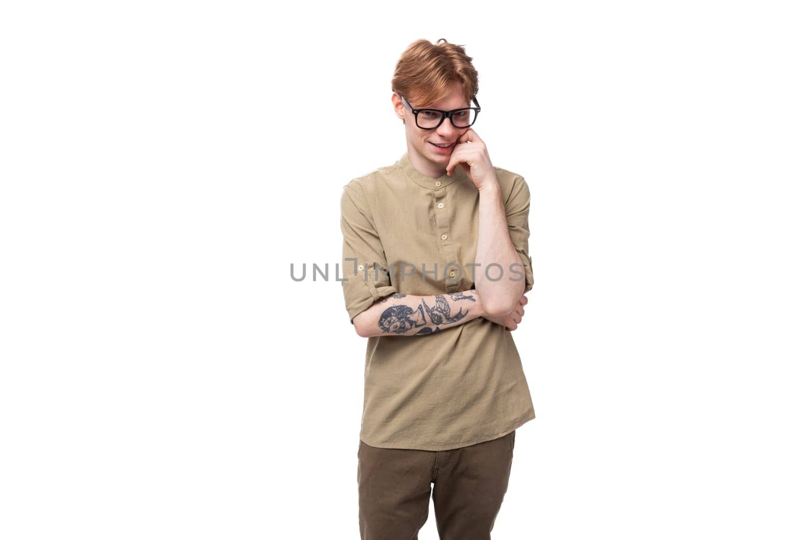 young smart european male student with red golden hair dressed in a light brown shirt thought by TRMK