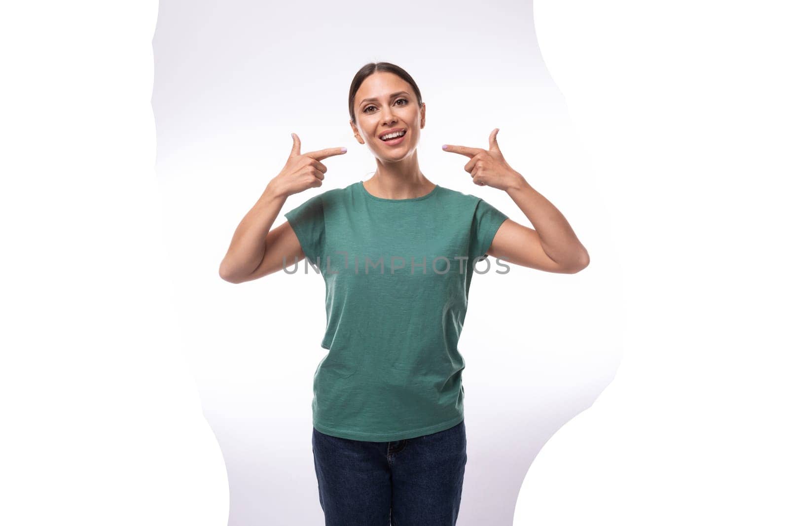 30 year old smiling slender brunette woman with collected hair is dressed in a green basic t-shirt and jeans by TRMK