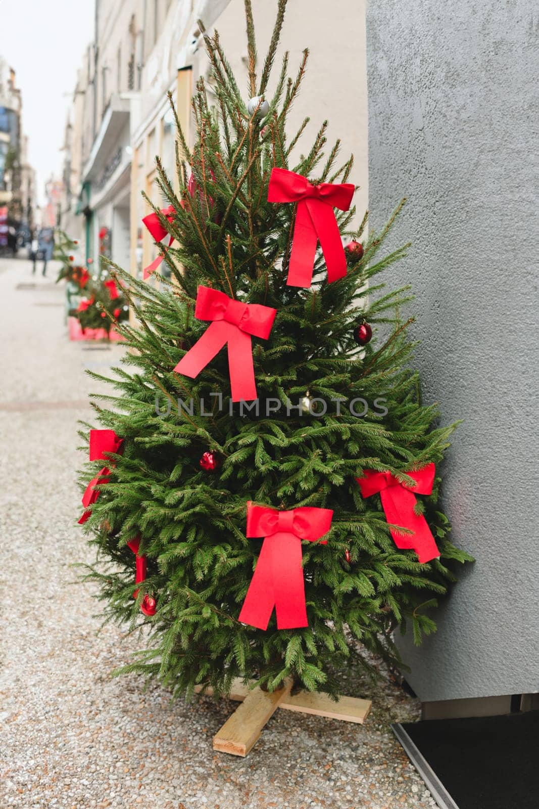 Christmas tree in the city decorated with red bows