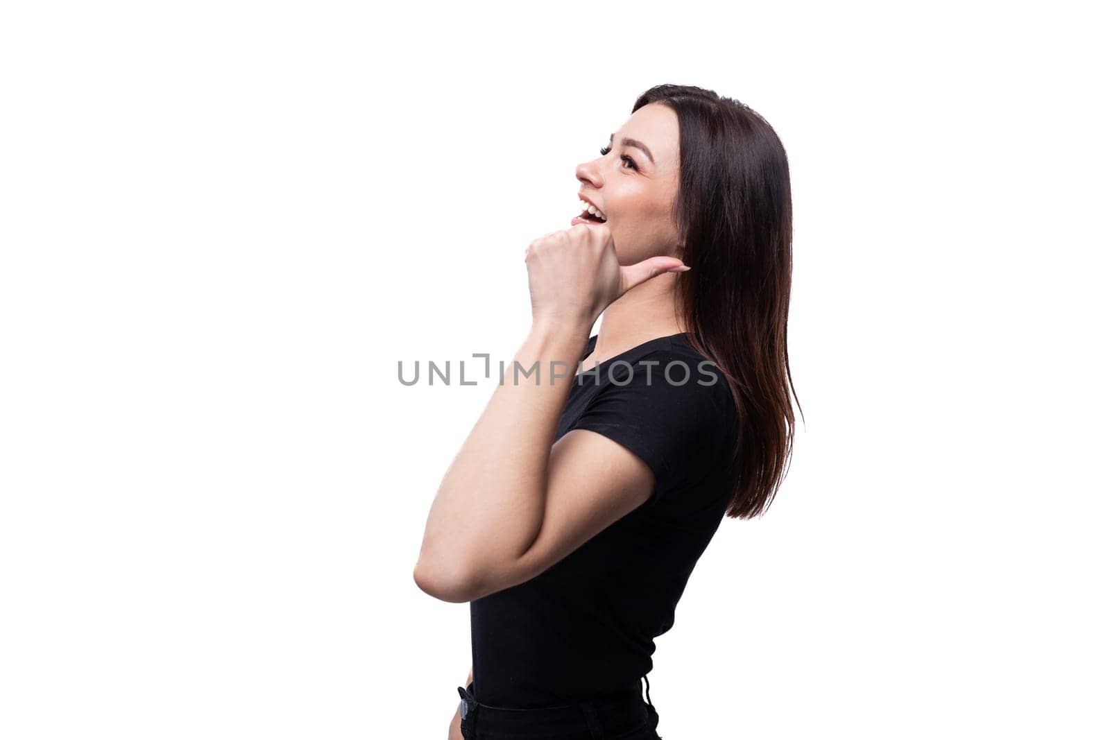 Young surprised woman with brown eyes dressed in a black T-shirt on a background with copy space by TRMK