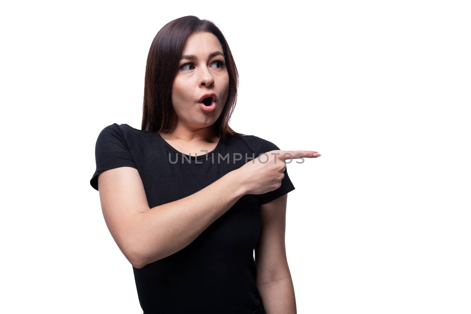 Caucasian young brunette woman with black hair points her finger in surprise.